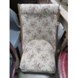 A brown floral fabric oak easy chair