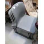 Four moulded grey plastic stacking chairs