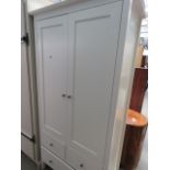 A cream painted double wardrobe, with three drawers unders
