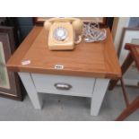 An oak lamp table, with cream painted base and drawer