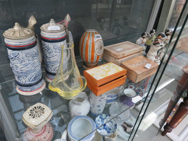 Shelf of assorted household decorative items to include blue and white tankards, painted egg