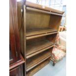 An oak finished four tier book case with glazed doors