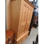 A pine double wardrobe with drawer under