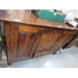 A dark wood sideboard with central drawers