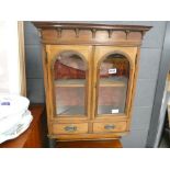 Glazed double door hanging cabinet with 2 drawers below