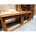 A teak coffee table with two nesting under
