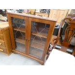 A reproduction glazed double door bookcase