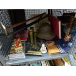 Cage containing a military helmet, a foot pump a brass door stop, brass shells, DVDs and figures