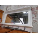 Hanging white framed mirror with integral coat hooks