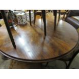 Circular walnut dining table on single pedestal 3 star base