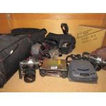 Shelf of various film cameras, video cameras, car stereo, binoculars, etc.