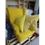 Mustard upholstered wing back armchair and cushions