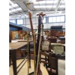 4 walking sticks and a brass stick stand