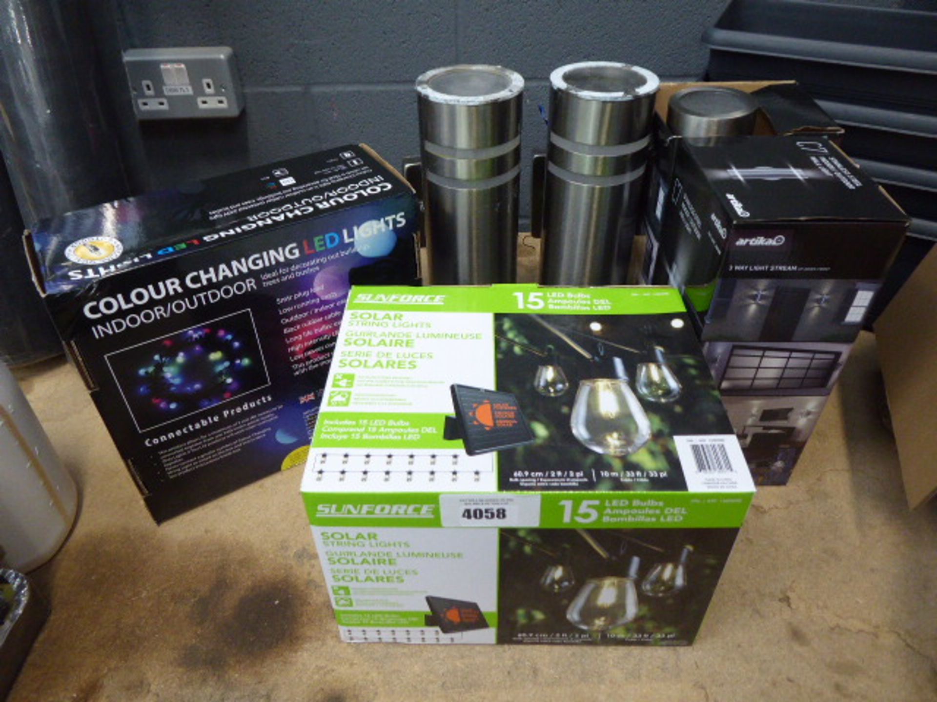 Box of colour changing LED lights, Sunforce solar sting lights, and Artika post lights