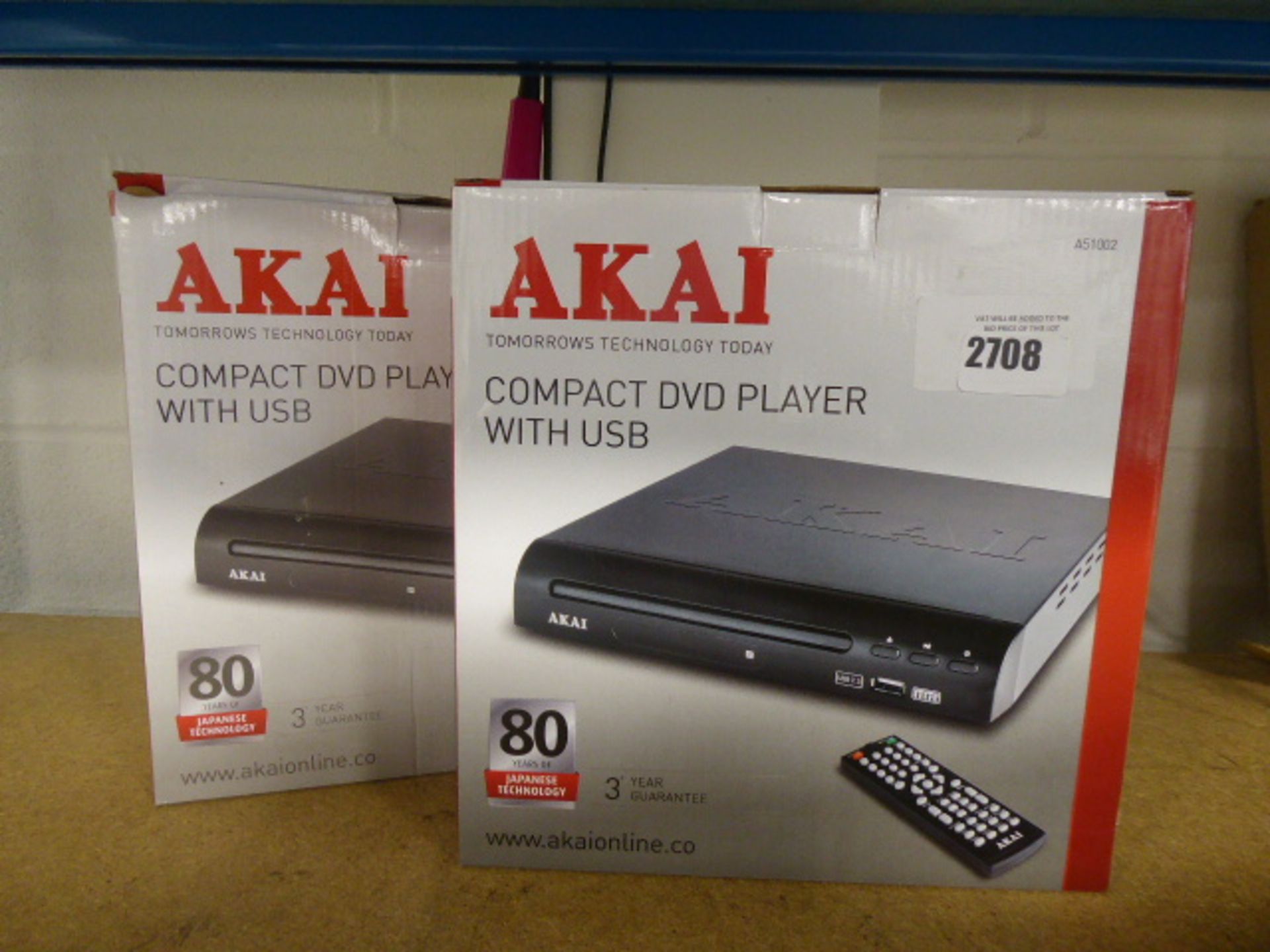 Two Akai compact DVD players with boxes