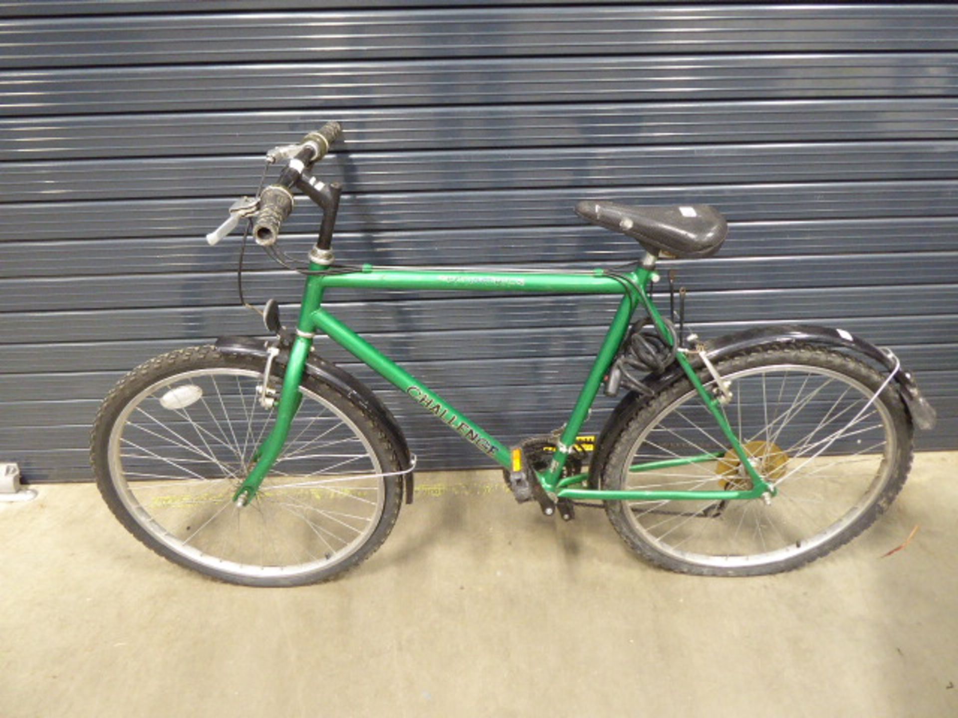 Green gents mountain bike with a quantity of spare tyres and wheel