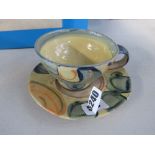 38 Mid C - A studio pottery cup and saucer with yellow and blue glazes, moulded RW to base, possibly