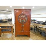 A late 20th century Oriental two door hall cabinet, painted red and decorated with traditional