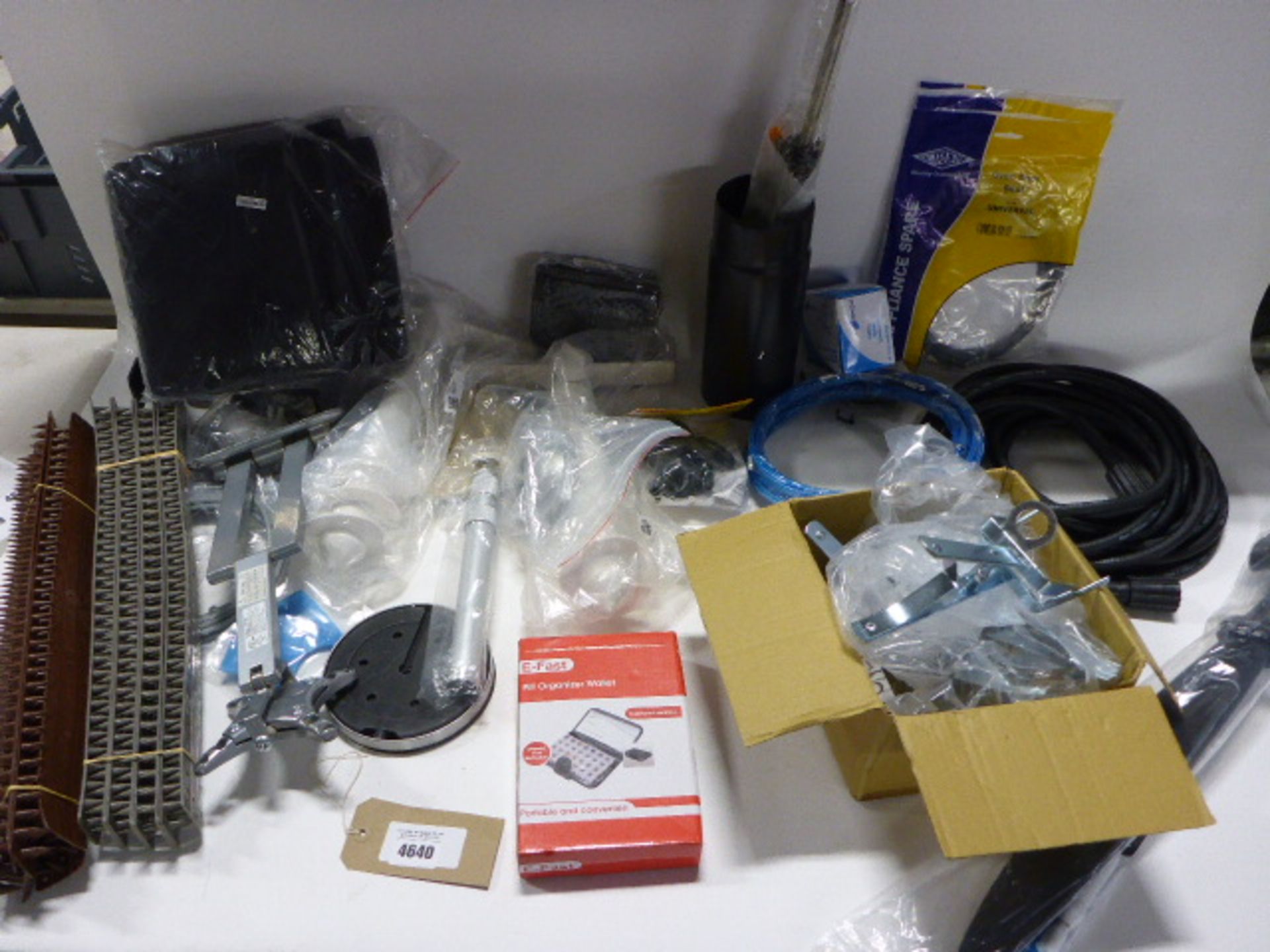 Bag containing fence spikes, pill organiser, mole traps, fake plastic sword, pressure washer hose,