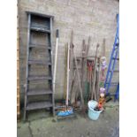 Selection of outdoor garden tools incl rakes, spades, forks, hoes, etc. with a set of wooden ladders