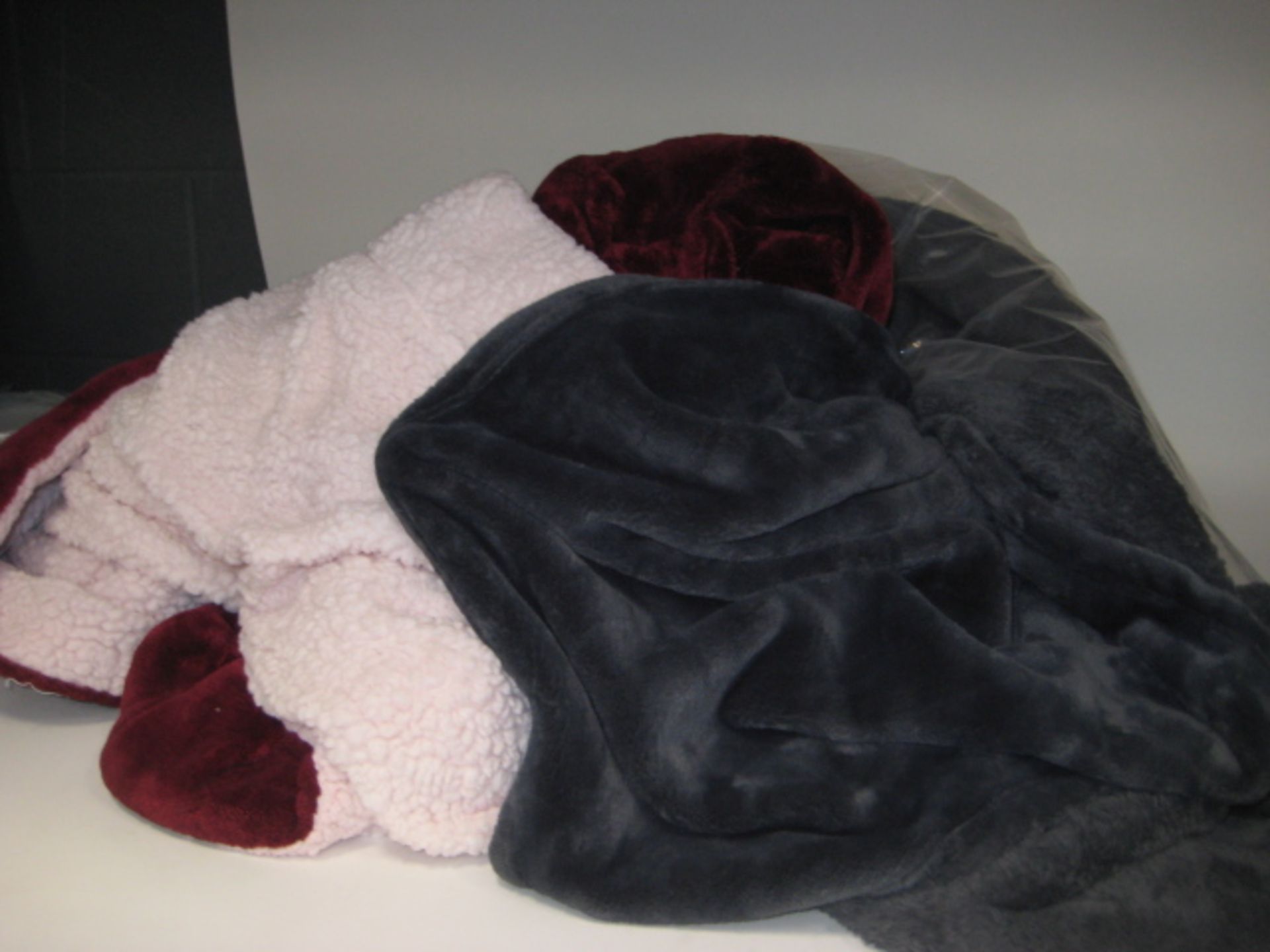 Bag containing 2 large throws; 1 in grey, 1 in red and pink