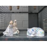 A cage containing a quantity of Nao and Lladro figures, plus an ornamental Italian cat