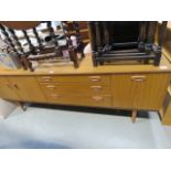 Teak finished sideboard with three central drawers