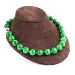 A single strand continuous green jade bead necklace, l. 50 cm, average d. 1.