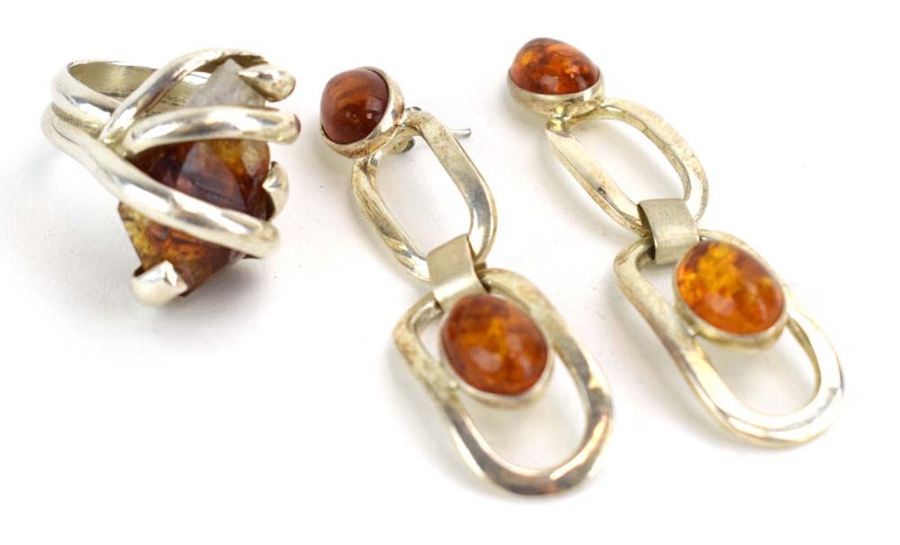 A late 20th century silver dress ring set amber coloured quartz within an entwined setting,