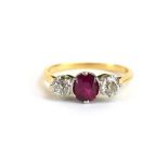 A yellow metal ring set round cut ruby and two old brilliant cut diamonds in an inline setting,