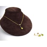 A 9ct yellow gold ropetwist necklace suspending a pendant set cultured pearl and teardrop peridot,