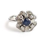 A 14ct white gold dress ring centrally set a brilliant cut sapphire and small diamonds in an