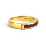 An 18ct yellow gold half eternity ring set seven square cut rubies in a channel setting,