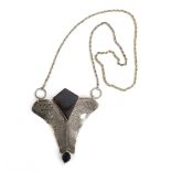 A late 20th century pressed metalware pendant decorated with star motifs and set black (?)onyx on a