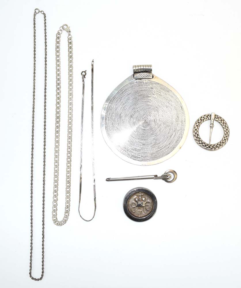 A mixed parcel of silver and metalware jewellery comprising a pendant of archaic circular form, d.