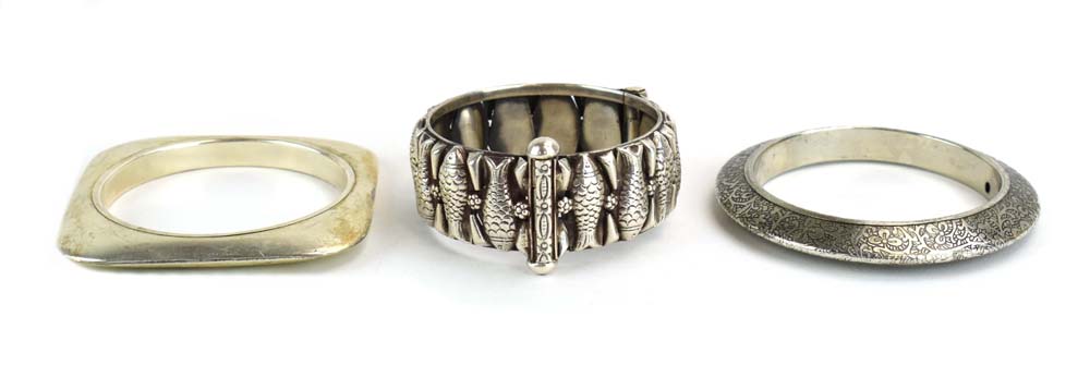 A late 20th century Continental metalware hinged bracelet relief decorated with stylised fish and