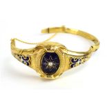 A 19th century gilt metal hinged bracelet decorated in blue enamel in the Etruscan manner,