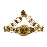 A 9ct yellow gold four bar gatelink bracelet set half sovereign dated 1982 in a loose mount,
