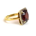 An 18ct yellow gold cluster ring set square cushion cut garnet within a border of twenty-six small