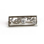 A white metal openwork brooch of rectangular form set two principle diamonds and smaller diamonds