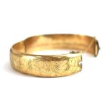 A 9ct yellow gold florally engraved hinged bracelet, Birmingham 1964, 20.