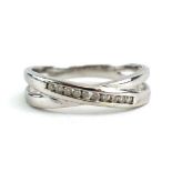 A 9ct white gold crossover ring set nine small diamonds in a channel setting, ring size O 1/2, 2.