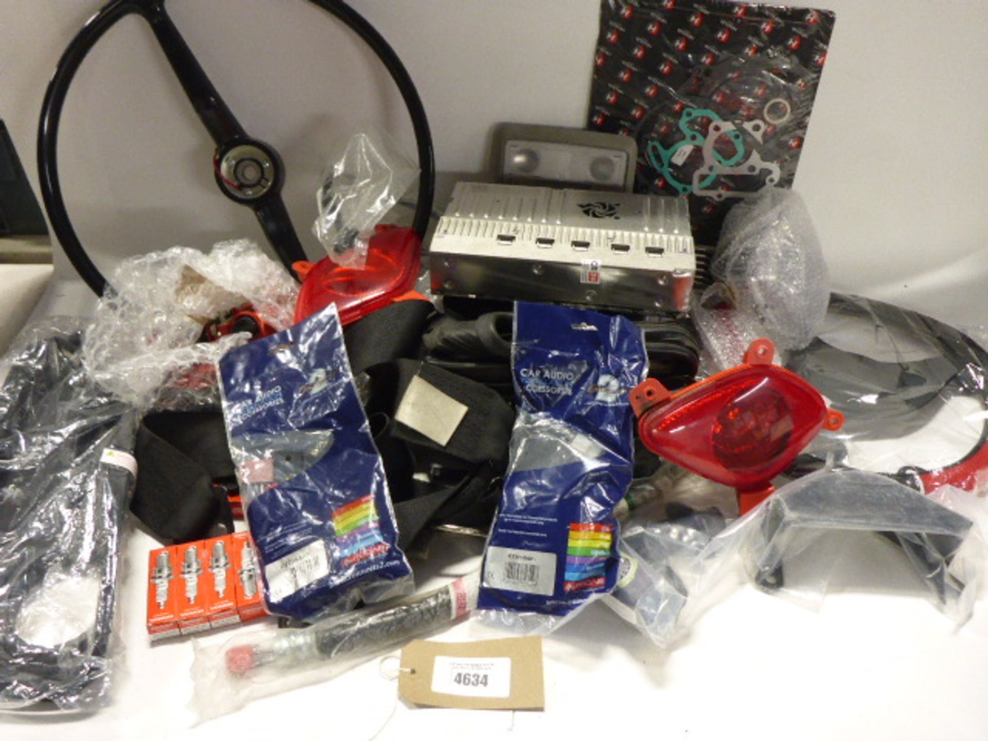 Bag containing spark plugs, car audio installation accessories, vintage steering wheel, gaskets,