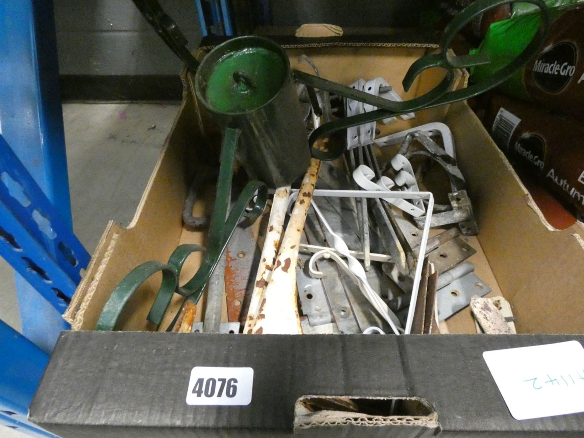 Box containing gate hinges, brackets and a Christmas tree stand