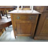 An oak side table with single drawer and door