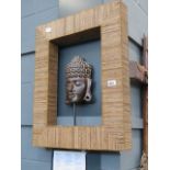 A framed mask of Buddha