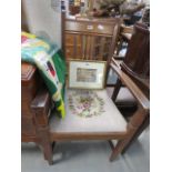 An oak armchair with embroidered seat