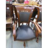 A brown leather swivel office armchair