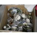 A box containing glassware, commemorative mugs and ornaments