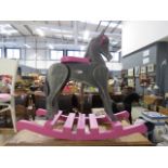 A grey and pink painted child's rocking horse